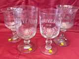 four wine glasses with yellow dots on them sitting on a red cloth