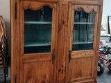 une vieille armoire en bois avec des portes vitrées dans une pièce
