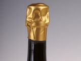 bottle of wine with a gold cap on a grey background