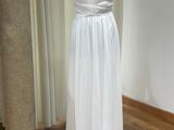 a white dress on a mannequin stand in a room
