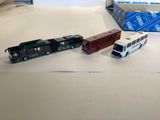 three toy trains on a table with a box in the background