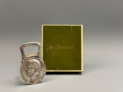 une image représentant une pièce de monnaie avec un décapsuleur devant une boîte
