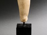 sculpture représentant un vase posé sur un socle noir, sur une surface grise
