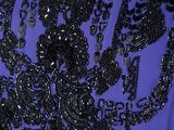 purple dress with black beading and black flowers on a mannequin neck