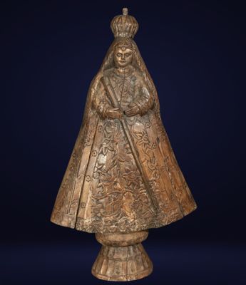 an antique bronze statue of a woman in a cloak and hat