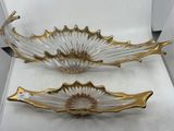 pair of gold and clear glass bowls sitting on top of a white table