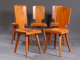 three wooden chairs sitting next to each other on a gray surface