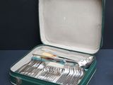 a green case with silverware in it on a table