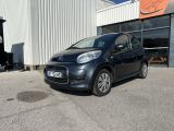 La petite voiture est garée devant un grand immeuble.