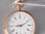 une montre de poche en or à laquelle est fixée une pince à cravate