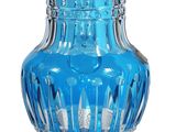a blue glass vase with a silver base on a white background