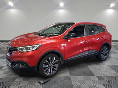 une voiture rouge est garée dans une pièce au sol en damier