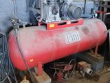 a red tank sitting in a room with a lot of tools