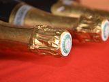 three bottles of champagne are lined up on a red table