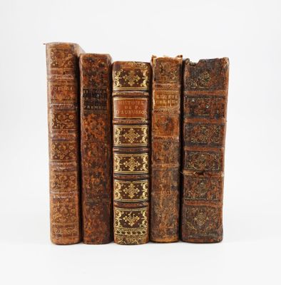 plusieurs vieux livres sont alignés sur une surface blanche