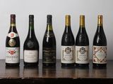 Des bouteilles de vin sont alignées sur une table devant un mur blanc.