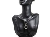black mannequin head with silver necklace and earrings on display