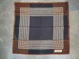 an image of a brown and black square scarf hanging on a wall