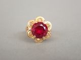 Gros plan sur une bague en or ornée d'une pierre rouge