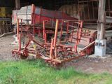 a red tractor that is parked in front of a barn