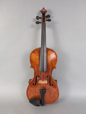 un vieux violon posé sur une table près d'un mur