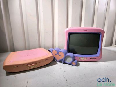 a pink and purple television and a pair of scissors on a table