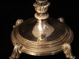 a silver plate with a candle on top of it