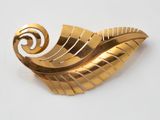 une image représentant une broche en or ornée d'un motif en spirale