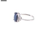 a close up of a ring with a blue stone and diamonds