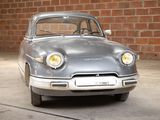 a silver car that is parked in front of a brick wall