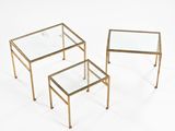 a set of three brass coffee tables with glass tops