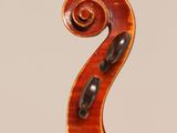 a close up of the back of a violin with a fiddle in the foreground