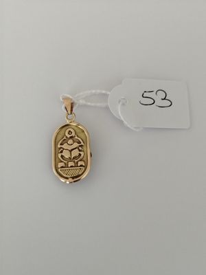 a gold pendant with a small bird on it