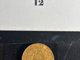 gros plan d'une pièce d'or sur une surface noire