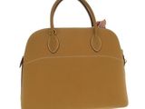 a close up of a brown handbag on a white background