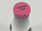 a close up of a bottle with a pink cap on it