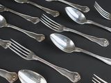 a lot of spoons and forks on a black table