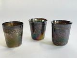 trois tasses de couleurs différentes posées les unes à côté des autres sur une surface blanche