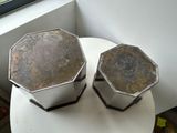 two metal pots sitting on a table next to a window