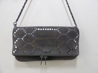 porte-monnaie en cuir gris orné de clous métalliques, suspendu à une chaîne