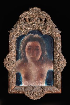 tableau représentant le visage d'une femme, dans un cadre argenté, sur fond noir