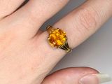 a woman ' s hand with a yellow ring on it