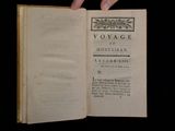someone is holding an old book open on a black surface