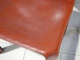 a brown leather chair that is sitting on a tile floor