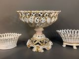three white and gold vases sitting on top of a table