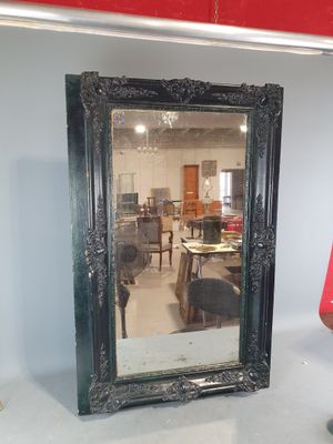 un miroir posé sur le sol à côté d'une chaise