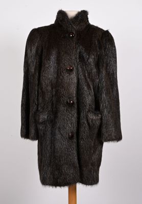 un manteau de fourrure noir sur un stand de mannequin