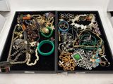 deux plateaux de bijoux posés sur une table