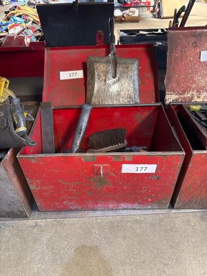 two red boxes with tools in them sitting on the floor
