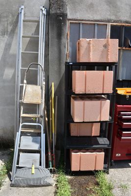 a stack of boxes and a ladder in front of a building